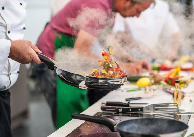 Tossing vegetables in a frying pan